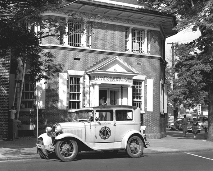 Police car in front of Farmer's Bank, 1958