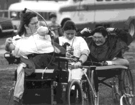 Photo: Three women in wheelchairs with bows and arrows