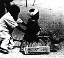Photo: Boy in hand made wheelchair.