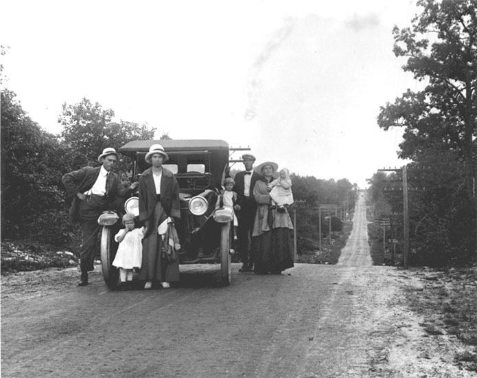 Family posing next to a car, 1915 circa
