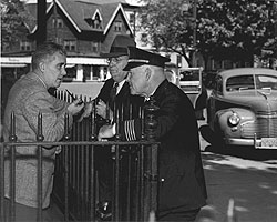 Three men talking in front of the county courthouse.