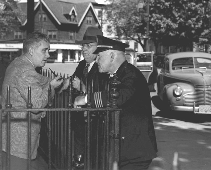 Three men talking in front of the court house, 1949