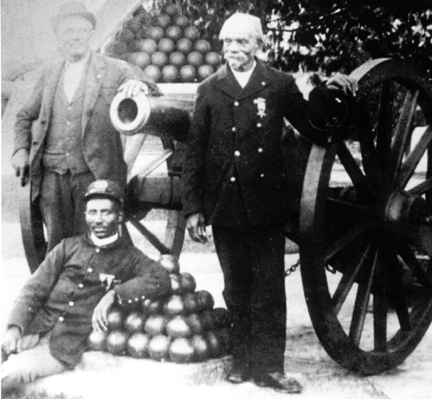 photo of African American solders standing in front of a cannon